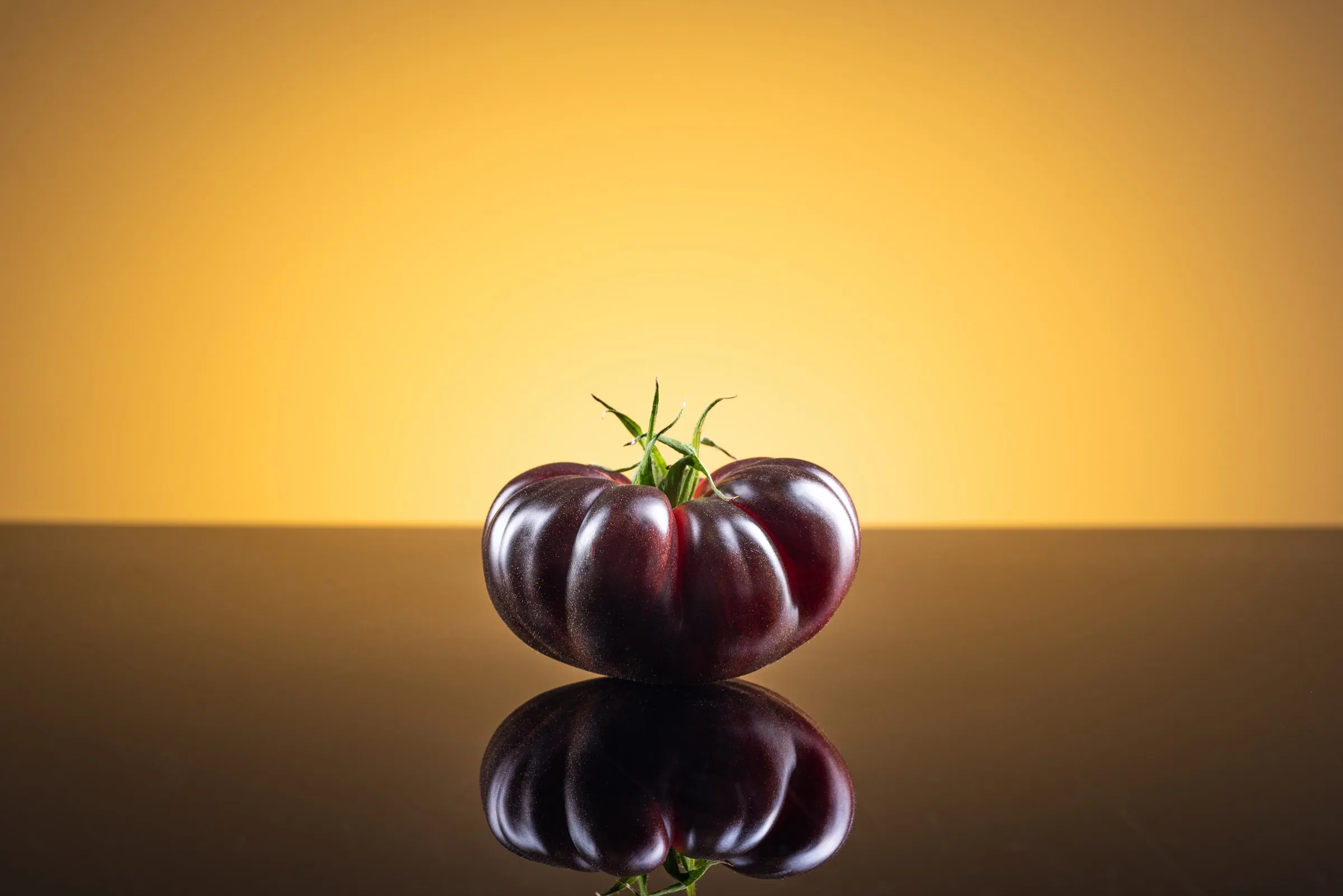 Whole Mystika tomato on a warm, amber-toned background.